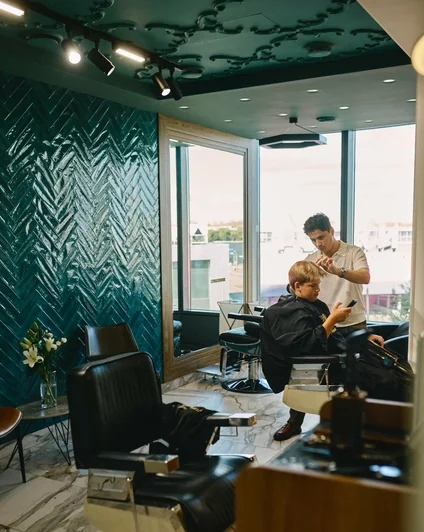 Интерьер SHON RAKHIMOV Premium Haircuts и мастер за работой